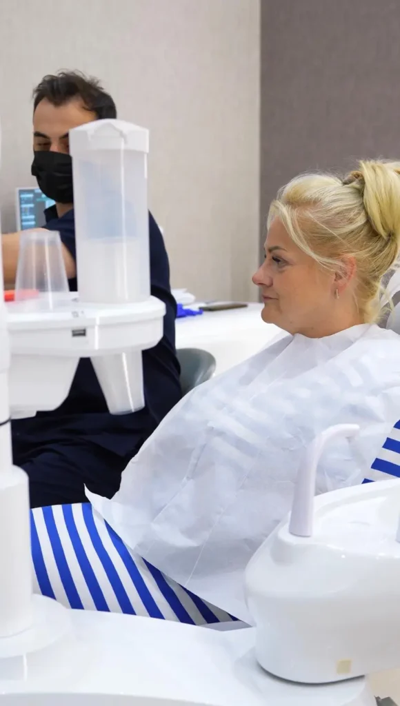 Patient Joanna sitting in a dental chair at Point Dental Clinic with a dentist in the background.